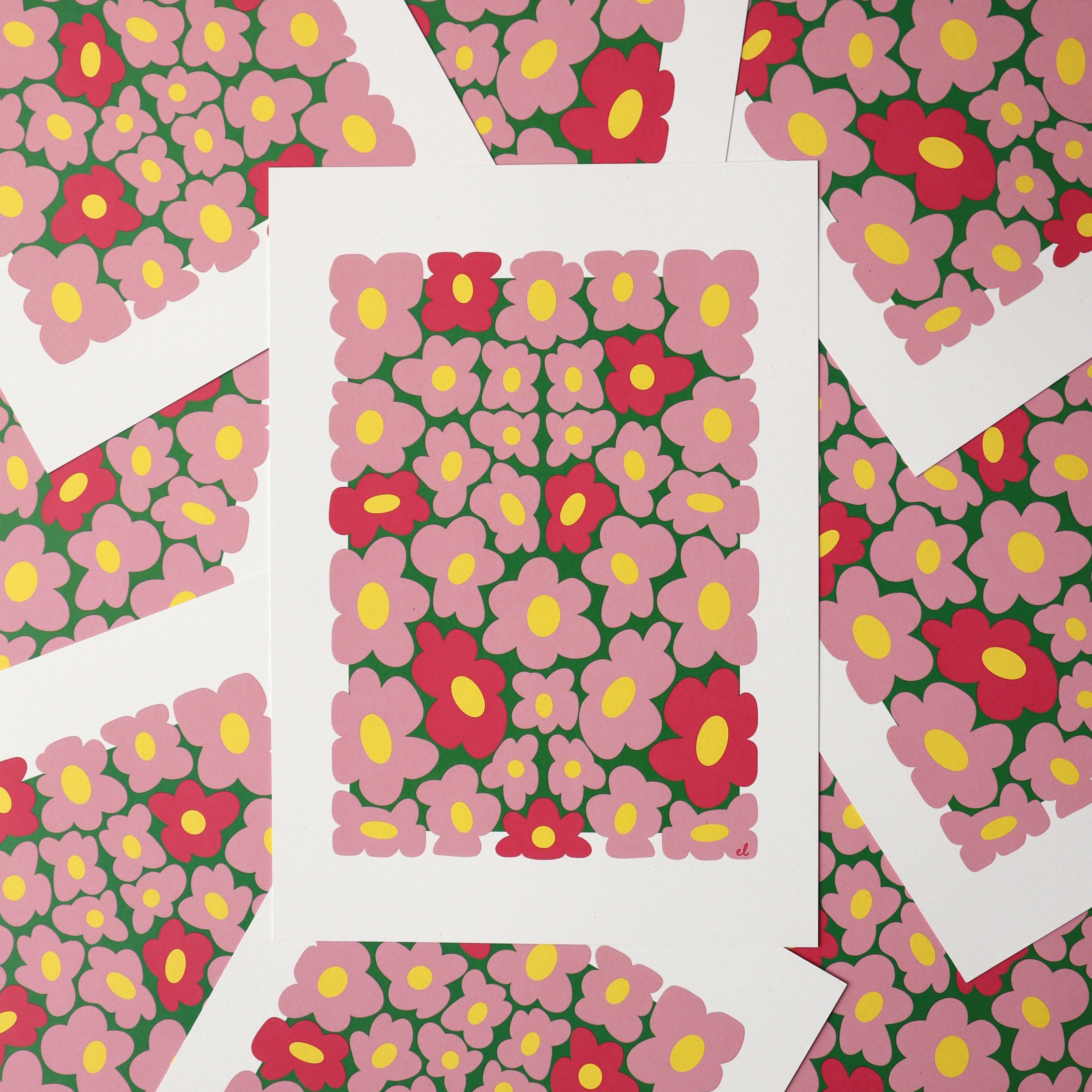A printed artwork featuring a whimsical pattern of wobbly pink daisies on a blue background, displayed overlapping with more of the same print