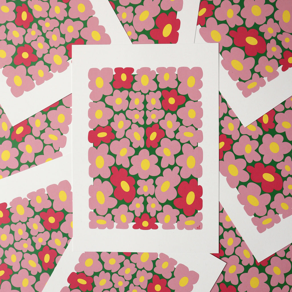 A printed artwork featuring a whimsical pattern of wobbly pink daisies on a blue background, displayed overlapping with more of the same print