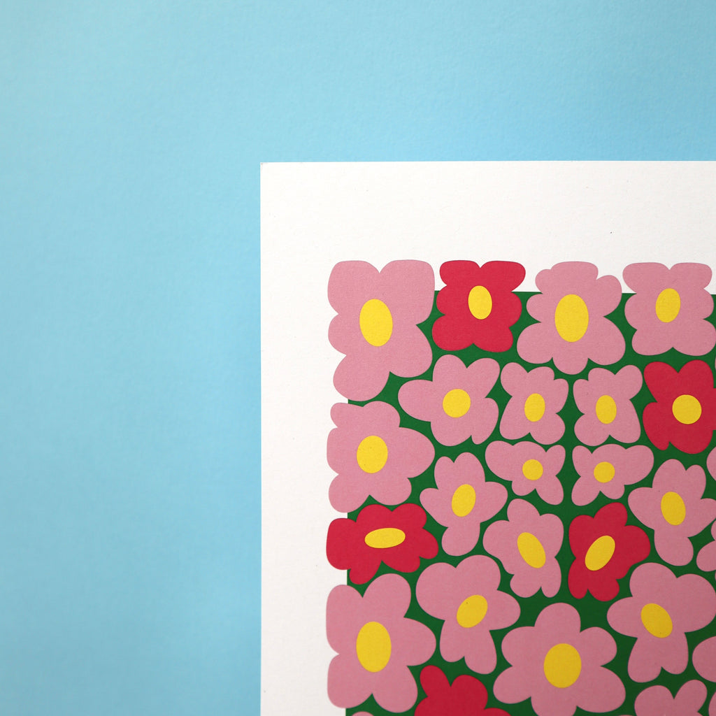 A printed artwork featuring a whimsical pattern of wobbly pink daisies on a blue background