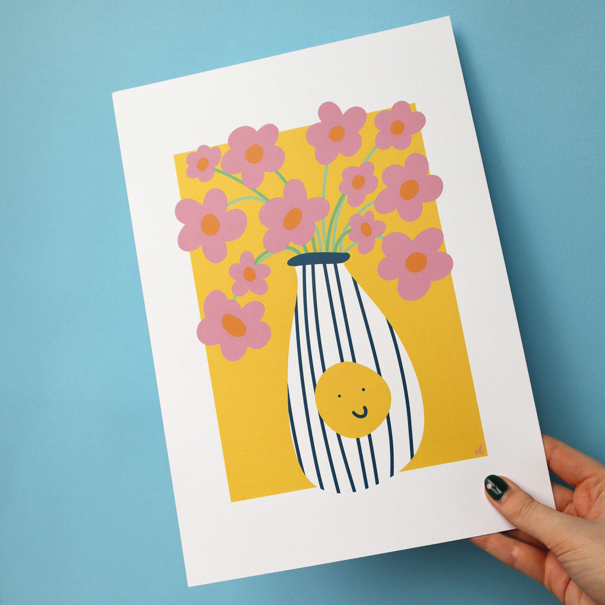A colourful artwork depicting a vase with a smiley face full of pink daisies, on a blue background being held up by a hand
